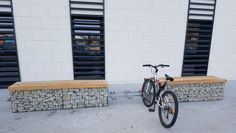 Support cycle acier avec vélo entre 2 bancs gabions bois et pierres blanches